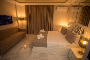 a bedroom with a large bed and a couch at Lux Apartment in Batumi