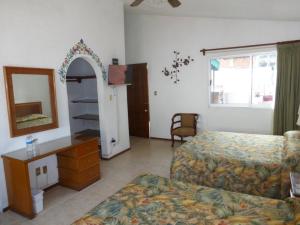 a bedroom with a bed and a dresser and a mirror at Hotel Bajo el Volcan in Cuernavaca