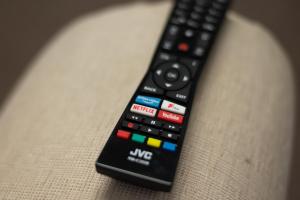 a remote control sitting on top of a couch at Alexandra Cottage Comfortable Apt near Swansea & M4 in Swansea