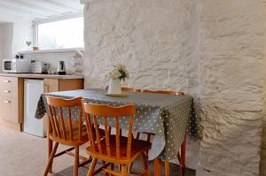 a kitchen with a table with chairs and a table cloth at Alexandra Cottage Comfortable Apt near Swansea & M4 in Swansea