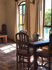 a dining room with a table and chairs and windows at Casa Grande in Zacatlán