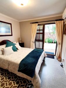 a bedroom with a bed and a large window at Mountain Rose Cottage in Bellville