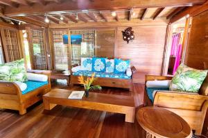 ein Wohnzimmer mit Sofas und einem Tisch in der Unterkunft Fare Makana in Maharepa