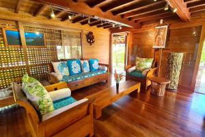 a living room with two couches and a tv at Fare Makana in Maharepa