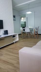 a white living room with a table and a tv at Flat Espinheiro Prime in Recife
