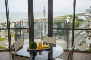 a dining room with a table and a view of the ocean at Lux Apartment in Batumi