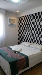1 dormitorio con 1 cama con pared a cuadros en Flat Espinheiro Prime, en Recife