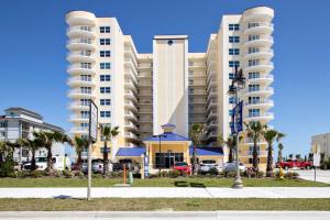 a large apartment building with palm trees in front of it at Aruba Condo Unit #1102 in Daytona Beach Shores