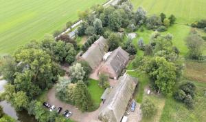 una vista aérea de una mansión con coches estacionados en un campo en Hotel Gut Schöneworth, en Freiburg - Elbe