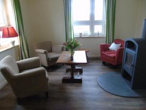 ein Wohnzimmer mit Stühlen, einem TV und einem Tisch in der Unterkunft Futterhaus neben der Wasserburg Liepen in Gielow