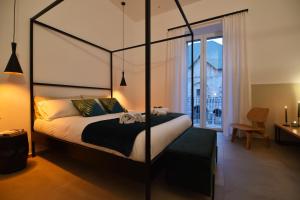 - une chambre avec un lit à baldaquin et une fenêtre dans l'établissement First Floor B&B, à Bari