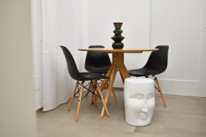un tavolo con sedie nere e un tavolo con un vaso di First Floor B&B a Bari