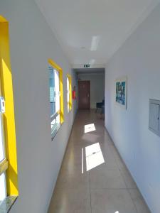 un pasillo vacío en un edificio con paredes amarillas y blancas en Hotel Hiperion Maringá, en Maringá