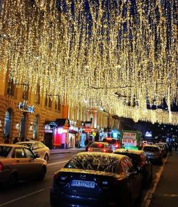 una strada di città con macchine parcheggiate sotto un mucchio di luci di Хостел Мажор a Charkiv