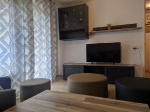 a living room with a tv and a table and chairs at Hiša Belin in Podbela