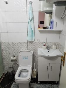 a small bathroom with a toilet and a sink at Diar Apartment in Durrës