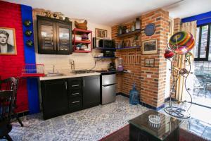 a kitchen with black cabinets and a brick wall at Majikal B&B - Diego Rivera in Cholula