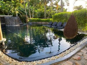 a pool of water with chairs and a fountain at Casa Barbara in Las Terrenas