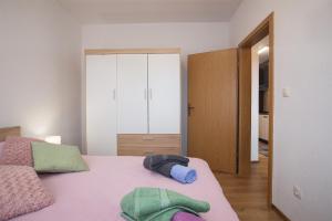 a bedroom with a pink bed with two towels on it at Apartment Little Gallery **** in Rovinj