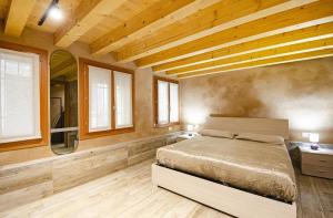 Schlafzimmer mit einem Bett sowie Holzdecken und -fenstern in der Unterkunft Ca' Nane in Venedig