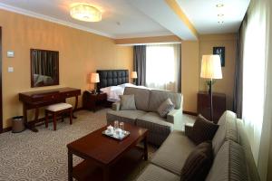 Cette chambre d'hôtel dispose d'un salon avec un lit. dans l'établissement Platinum Hotel Ulaanbaatar, à Oulan-Bator