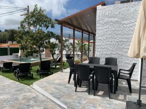 une terrasse avec une table, des chaises et une piscine dans l'établissement Casa Juani, à Las Palmas de Gran Canaria