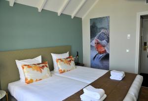 a bedroom with two beds and a painting on the wall at Hotel Spaander BW Signature Collection in Volendam