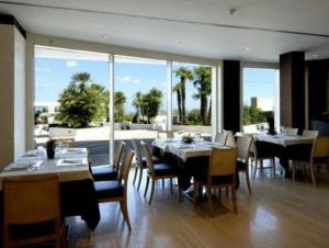 jadalnia ze stołami i krzesłami oraz dużym oknem w obiekcie Hotel Pineta Wellness & Spa w mieście Ruvo di Puglia