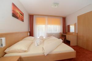 Rúm í herbergi á Strandhotel Faak