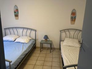 dwa łóżka w pokoju ze stołem i lampką w obiekcie gîte la source milieu w mieście Vias
