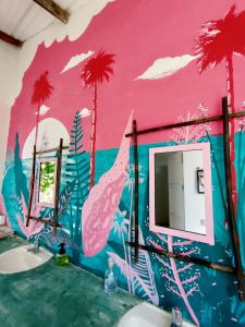 a bathroom with a mural of palm trees on the wall at Hostal El Bohío in Palomino