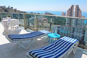 d'un balcon avec deux chaises et une table. dans l'établissement Apartamento de Lujo con terraza privada y vistas al mar en Torre Lúgano, à Benidorm