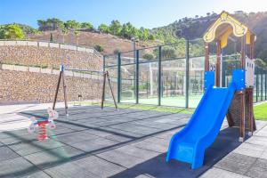 a playground with a blue slide and a monkey bars at Skyline 20 Apartamento de Lujo con terraza privada y vistas al mar in Benidorm