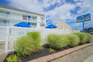 a white fence with blue umbrellas in front of a building at The Crossings Ocean City in Ocean City