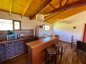 a kitchen with a wooden counter and a refrigerator at Cabaña El Churqui in Tafí del Valle