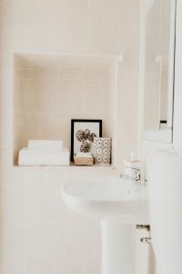 a white sink sitting under a mirror in a bathroom at Residencial Avenida in Faro