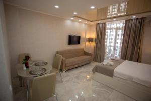a hotel room with a bed and a couch and a table at Lux Apartment in Batumi