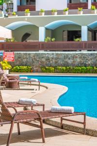 uma piscina com duas cadeiras e uma piscina em Grande Hotel da Barra em Salvador