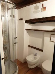 a bathroom with a toilet and a glass shower at B&B e Home Restaurant S'ispera Monolocale uso esclusivo in Fonni