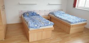 two beds in a room with wooden floors at Na panskym in Lom u Mostu