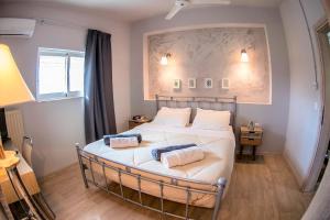 a bedroom with a bed with two pillows on it at Nataly's Gardens with Pool Lagonissi in Lagonissi +201 photos