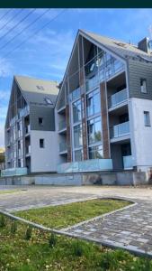 a large white building with a lot of windows at Nowoczesny Apartament z widokiem na jezioro in Charzykowy