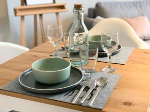 a table with a bowl and plates and wine glasses at Premium CityApartment *Tiefgarage,Netflix,Zentrum* in Cottbus