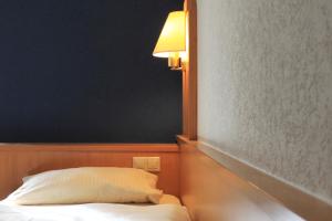 una camera da letto con un letto con una lampada a muro di Alte Nagelschmiede ad Altdorf bei Nuernberg