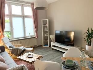 a living room with a couch and a tv at Premium CityApartment *Tiefgarage,Netflix,Zentrum* in Cottbus