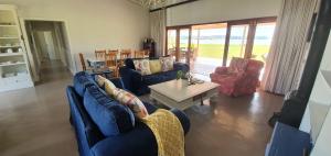 una sala de estar con sofás azules y una mesa. en Riverside Farm, en Witbank