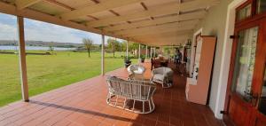 a porch of a house with a table and chairs at Riverside Farm in Witbank