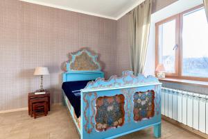 a bedroom with a blue bed and a window at Villa Santa Agata in Bobritsa