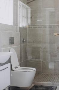 een badkamer met een toilet en een douche bij The Living Collective Villa in Hilton