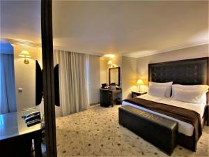 ein Hotelzimmer mit einem großen Bett und einem Schreibtisch in der Unterkunft Maxi Park Hotel & Spa in Welingrad